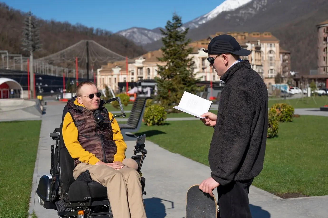 Plano medio de un hombre leyéndole a su amigo.